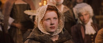 Movie still from “Perfume: The Story of a Murderer” (2006), directed by Tom Tykwer – A woman with red hair wearing a white hat; Close Up shot, High angle