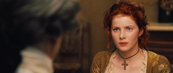 Movie still from “Perfume: The Story of a Murderer” (2006), directed by Tom Tykwer – A woman with red curly hair is looking at the camera; Close Up shot, Over the shoulder angle
