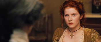 Movie still from “Perfume: The Story of a Murderer” (2006), directed by Tom Tykwer – A beautiful young woman with red hair wearing a necklace; Close Up shot, Over the shoulder angle