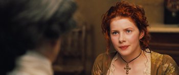 Movie still from “Perfume: The Story of a Murderer” (2006), directed by Tom Tykwer – A woman with red curly hair is looking at the camera; Close Up shot, Over the shoulder angle