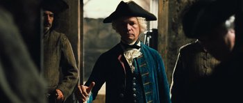 Movie still from “Perfume: The Story of a Murderer” (2006), directed by Tom Tykwer – A man wearing a hat and a blue jacket; Medium shot, Low angle