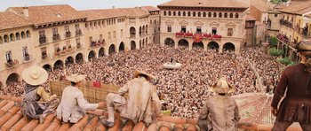Movie still from “Perfume: The Story of a Murderer” (2006), directed by Tom Tykwer – A crowd of people sitting on top of a building; Extreme Wide shot, Overhead angle