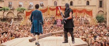 Movie still from “Perfume: The Story of a Murderer” (2006), directed by Tom Tykwer – Two people on a stage in front of an audience; Wide shot, Over the shoulder angle