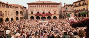 Movie still from “Perfume: The Story of a Murderer” (2006), directed by Tom Tykwer – A crowd of people sitting in front of a large building; Extreme Wide shot, High angle