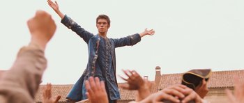 Movie still from “Perfume: The Story of a Murderer” (2006), directed by Tom Tykwer – A young man in a medieval costume is waving to the crowd; Medium shot, Low angle