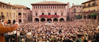 Movie still from “Perfume: The Story of a Murderer” (2006), directed by Tom Tykwer – A crowd of people standing in front of a large building; Extreme Wide shot, High angle