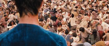 Movie still from “Perfume: The Story of a Murderer” (2006), directed by Tom Tykwer – A group of people sitting on the ground; Wide shot, High angle
