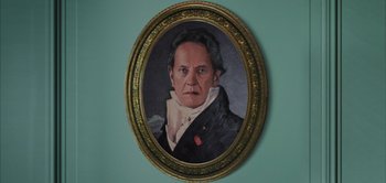Movie still from “Persuasion” (2022), directed by Carrie Cracknell – A painting of a man in a black jacket; Close Up shot, High angle