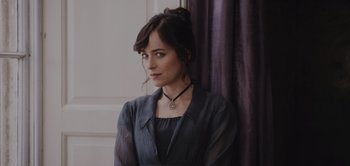 Movie still from “Persuasion” (2022), directed by Carrie Cracknell – A woman in a black dress and a black necklace; Close Up shot, High angle