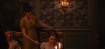 Movie still from “Persuasion” (2022), directed by Carrie Cracknell – A young girl getting her hair done by a woman; Medium shot, Over the shoulder angle