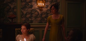 Movie still from “Persuasion” (2022), directed by Carrie Cracknell – A woman standing next to a girl in a green dress; Medium shot, Over the shoulder angle