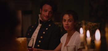 Movie still from “Persuasion” (2022), directed by Carrie Cracknell – A man and a woman sitting next to each other at a dinner table; Close Up shot, Over the shoulder angle