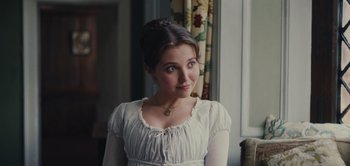 Movie still from “Persuasion” (2022), directed by Carrie Cracknell – A woman in a white dress looking at the camera; Close Up shot, Over the shoulder angle