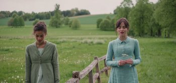 Movie still from “Persuasion” (2022), directed by Carrie Cracknell – Two women standing next to each other on a field; Medium shot, Over the shoulder angle