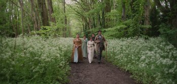 Movie still from “Persuasion” (2022), directed by Carrie Cracknell – A group of people walking down a dirt road; Wide shot, High angle