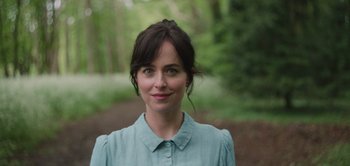 Movie still from “Persuasion” (2022), directed by Carrie Cracknell – A person wearing a blue shirt near a forest; Close Up shot, High angle