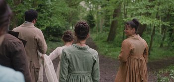 Movie still from “Persuasion” (2022), directed by Carrie Cracknell – A group of people standing on a dirt path; Medium shot, Over the shoulder angle