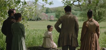 Movie still from “Persuasion” (2022), directed by Carrie Cracknell – A man and a woman sitting on top of a tree stump; Wide shot, Over the shoulder angle
