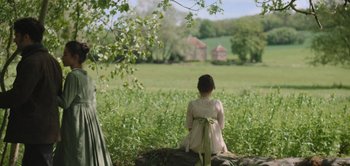 Movie still from “Persuasion” (2022), directed by Carrie Cracknell – A little girl sitting on top of a rock in a field; Wide shot, Over the shoulder angle