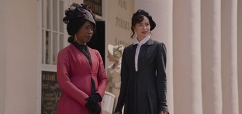 Movie still from “Persuasion” (2022), directed by Carrie Cracknell – Two women dressed in period clothing standing next to each other; Medium shot, Over the shoulder angle