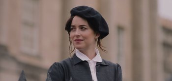 Movie still from “Persuasion” (2022), directed by Carrie Cracknell – A woman wearing a black hat and a white shirt; Close Up shot, Over the shoulder angle