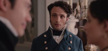Movie still from “Persuasion” (2022), directed by Carrie Cracknell – A man in a blue jacket and a white shirt; Close Up shot, Over the shoulder angle