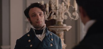 Movie still from “Persuasion” (2022), directed by Carrie Cracknell – A man wearing a blue jacket and a white shirt; Close Up shot, Over the shoulder angle