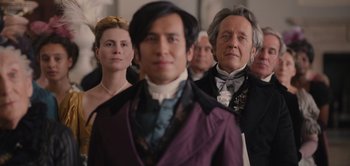 Movie still from “Persuasion” (2022), directed by Carrie Cracknell – A group of people standing next to each other in formal wear; Medium shot, Over the shoulder angle