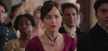 Movie still from “Persuasion” (2022), directed by Carrie Cracknell – A woman in a red dress and a black necklace; Close Up shot, Over the shoulder angle