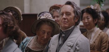 Movie still from “Persuasion” (2022), directed by Carrie Cracknell – An older man and woman standing next to each other; Close Up shot, Over the shoulder angle