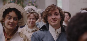 Movie still from “Persuasion” (2022), directed by Carrie Cracknell – A group of people standing next to each other wearing hats; Close Up shot, Over the shoulder angle