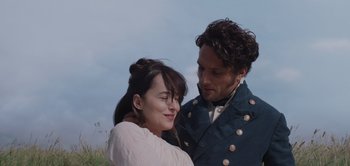 Movie still from “Persuasion” (2022), directed by Carrie Cracknell – A man and a woman standing next to each other in a field; Close Up shot, Over the shoulder angle