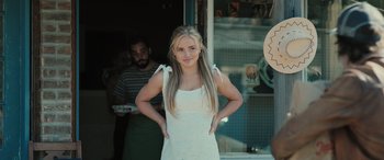 Movie still from “Pet Sematary: Bloodlines” (2023), directed by Lindsey Anderson Beer – A woman standing in front of a store window with her hands on her hips; Medium shot, Over the shoulder angle