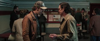 Movie still from “Pet Sematary: Bloodlines” (2023), directed by Lindsey Anderson Beer – Two men talking to each other in front of a building; Medium shot, Over the shoulder angle