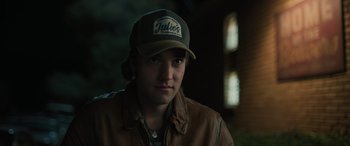 Movie still from “Pet Sematary: Bloodlines” (2023), directed by Lindsey Anderson Beer – A young man wearing a baseball cap and a leather jacket; Close Up shot, Over the shoulder angle