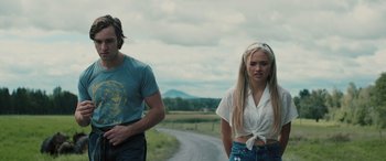 Movie still from “Pet Sematary: Bloodlines” (2023), directed by Lindsey Anderson Beer – A man and a woman standing next to each other on the side of a road; Medium shot, Low angle