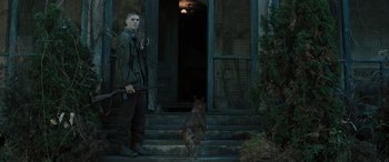 Movie still from “Pet Sematary: Bloodlines” (2023), directed by Lindsey Anderson Beer – A man and a dog standing in front of a house; Medium shot, Low angle
