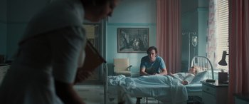 Movie still from “Pet Sematary: Bloodlines” (2023), directed by Lindsey Anderson Beer – A man sitting on a bed in a hospital room; Medium shot, Over the shoulder angle