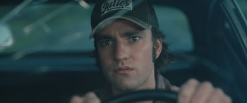 Movie still from “Pet Sematary: Bloodlines” (2023), directed by Lindsey Anderson Beer – A person wearing a hat driving a car; Close Up shot, Low angle
