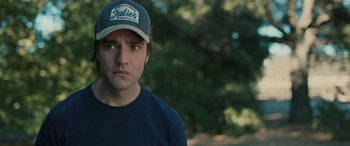 Movie still from “Pet Sematary: Bloodlines” (2023), directed by Lindsey Anderson Beer – A young man wearing a baseball cap and a blue shirt; Close Up shot, Over the shoulder angle