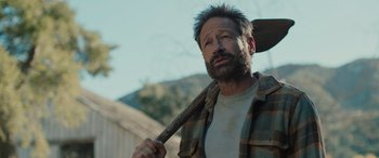 Movie still from “Pet Sematary: Bloodlines” (2023), directed by Lindsey Anderson Beer – A man holding a large axe in his hand; Close Up shot, Over the shoulder angle