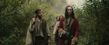 Movie still from “Pet Sematary: Bloodlines” (2023), directed by Lindsey Anderson Beer – A group of men walking through a forest; Medium shot, Low angle