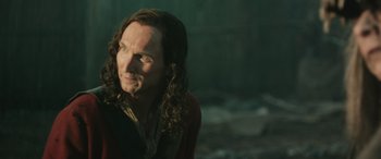 Movie still from “Pet Sematary: Bloodlines” (2023), directed by Lindsey Anderson Beer – A man with long hair is looking into the distance; Close Up shot, Over the shoulder angle