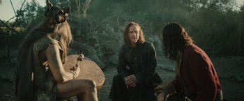 Movie still from “Pet Sematary: Bloodlines” (2023), directed by Lindsey Anderson Beer – A man sitting on the ground with two other people; Medium shot, Over the shoulder angle