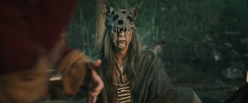 Movie still from “Pet Sematary: Bloodlines” (2023), directed by Lindsey Anderson Beer – A man with a wolf mask on his head; Close Up shot, Over the shoulder angle