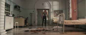 Movie still from “Pet Sematary: Bloodlines” (2023), directed by Lindsey Anderson Beer – A man standing in front of a floor covered in debris; Wide shot, Low angle