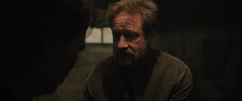 Movie still from “Pet Sematary: Bloodlines” (2023), directed by Lindsey Anderson Beer – An older man with a beard is looking at the camera; Close Up shot, Over the shoulder angle