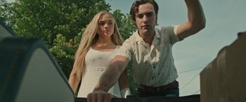 Movie still from “Pet Sematary: Bloodlines” (2023), directed by Lindsey Anderson Beer – A man and a woman standing next to each other in front of trees; Medium shot, Low angle