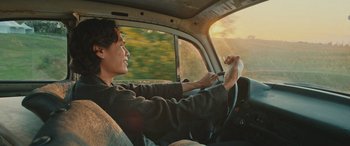 Movie still from “Pet Sematary: Bloodlines” (2023), directed by Lindsey Anderson Beer – A man sitting in the driver's seat of a car; Medium shot, Low angle