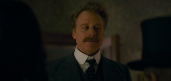 Movie still from “Peter Pan & Wendy” (2023), directed by David Lowery – A person wearing a suit and tie; Close Up shot, Low angle